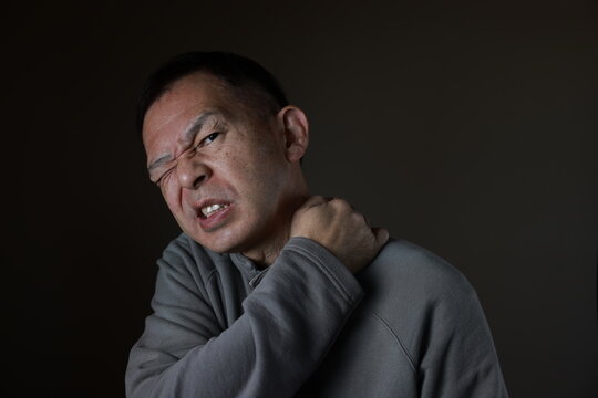 Middle-aged Japanese man in gray casual shirt on gray background. Conceptual image of world peace, stability in daily life, and sustainable living.