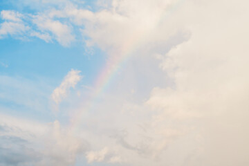 Fototapeta na wymiar clear sky rainbow background fluffy white clouds