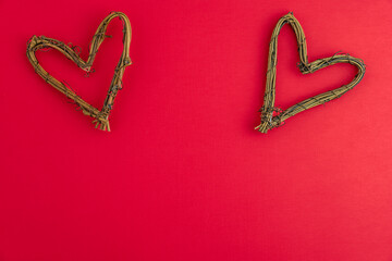 Heart shape made of dried grape vines on a red background, happy Valentine’s Day
