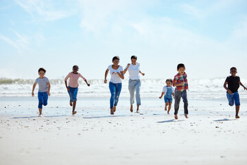 Summer, beach and a group of children running on sand, friendship and fun on ocean holiday. Friends, kids and energy in youth, happy boys and girls on vacation in playful race together at the sea.