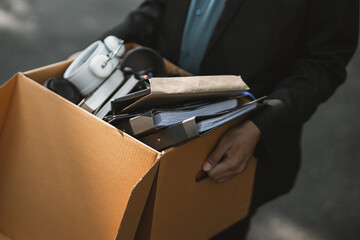 Businessman fired or resign from the company are carrying boxes down the street looking for a new job. Unemployed, hiring job, quitting job concept..