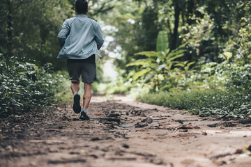 Fototapeta premium healthy lifestyle young fitness man running the forest. Outdoor workout, Healthy lifestyle concept.