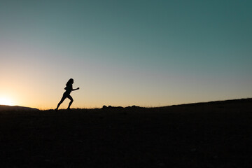 girl runs at sunset in the mountains.