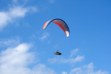 Paramotor sport. man driving a paramotor See the beautiful scenery cloudy sky background extreme sports concept