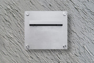 Modern aluminium mailbox for receive letter, newspaper and document that installed on grey concrete wall on building