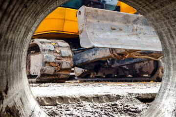 Close-up mini excavator during the construction of a modern residential complex. Miniature construction equipment for working in cramped conditions.