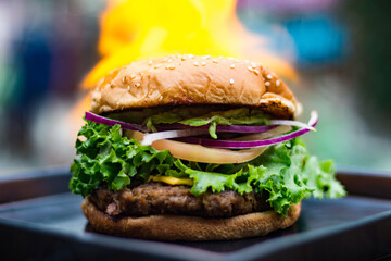 HAMBURGESA SERVIDA SOBRE PLATO EN LLAMAS
