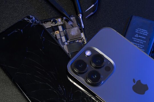 Apple iPhone 13 Pro on top of old iPhone and repair tools