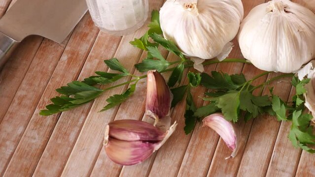 Parsley and garlic on wooden table. Preparing food concept.