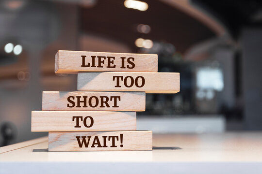 Wooden blocks with words 'Life Is Too Short To Wait'.