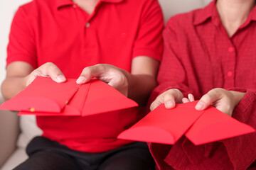 People hand giving Chinese red envelope, money gift for happy Lunar New Year holiday