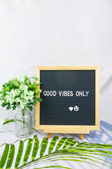 Letter board with phrase Good vibes only white background, flowers with heart. Concept of mental...