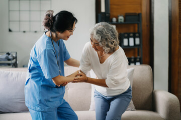 Obraz premium young caregiver assists her elderly woman patient at a nursing home. A senior woman is assisted by a nurse at home.
