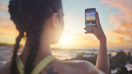 Beach, phone and woman taking photo of sunset for social media during evening workout in Bali....