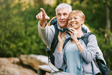 Elderly, couple hiking and bird watching with adventure outdoor, hike together and fitness for...