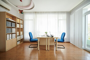 Empty business office with big table and two blue chairs