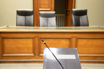 microphone of witnesses inside courtroom with judge and clerks workplace courthouse interior wooden...