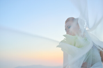 Fototapeta na wymiar Pretty woman posing in white wedding dress on Santorini island, Greece