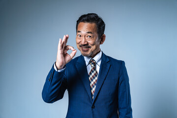 OKサインを見せる中年ビジネスマン