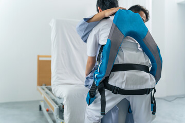 パワーアシストスーツをつけて患者を抱える看護師　移乗介助機器