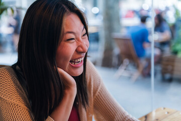 portrait of a young asian woman laughing happy, concept of relaxation and leisure