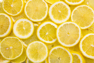 Bright lemon background. Lemon slices full frame.