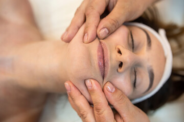 girl client is lying down for a facial massage in the best spa salon in town. - obrazy, fototapety, plakaty