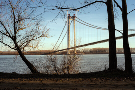 Suspension bridge over Danube in Braila, Romania seen through a gap in the forest trees.
