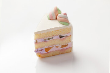 Slice of sponge cake with mascarpone cream, fruits and marshmallow