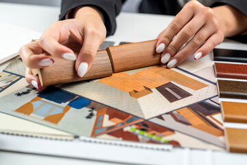 designer's hand selects floor and furniture materials from samples for home interior