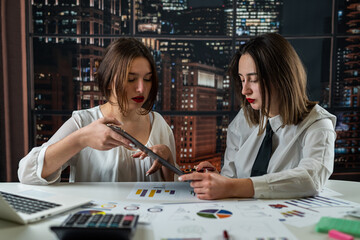 Fototapeta premium Female business team working together on financial document graph