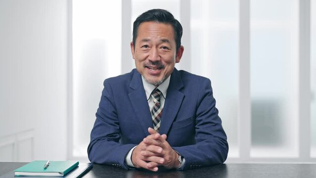 カメラ目線で話すビジネスマン　ビデオ通話　インタビュー