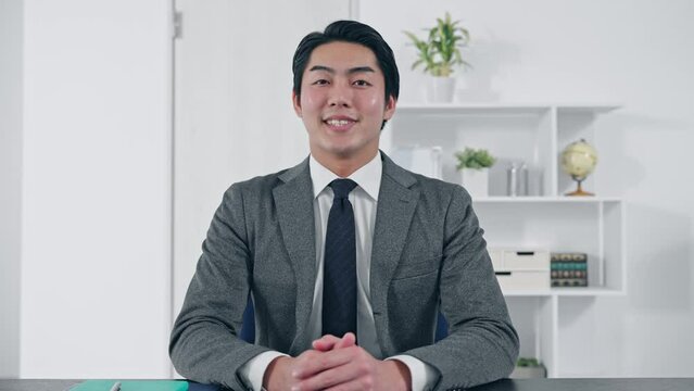 カメラ目線で話すビジネスマン　ビデオ通話　インタビュー