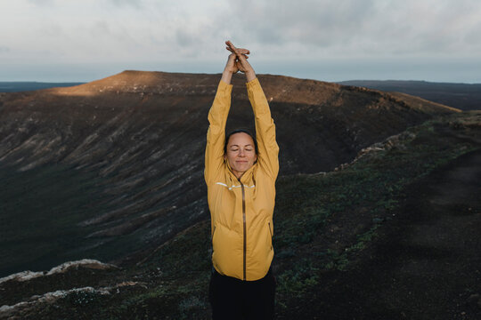 Woman with eyes closed exercising at Caldera Blanca volcano, Lanzarote, Canary Islands, Spain