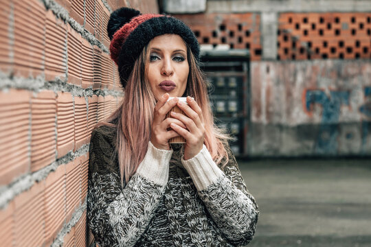 hipster woman drinking hot coffee in the street