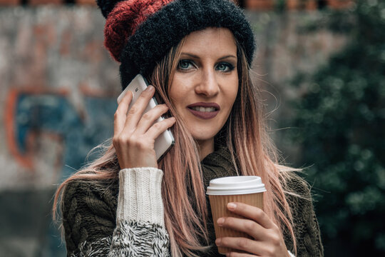 hipster girl with phone and coffee in the street
