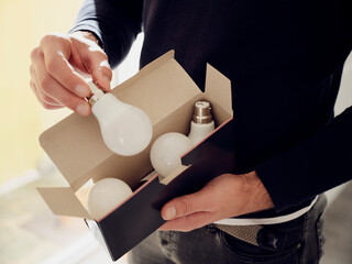 Close-up of man holding a box of LED lightbulbs
