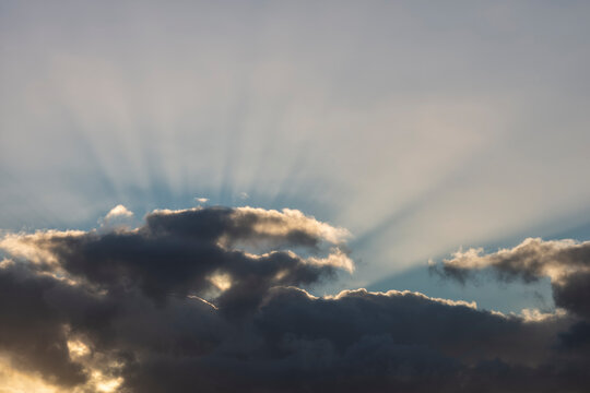 Gray clouds pierced by sunlight