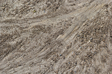 Dirty washed dirt road with traces of water flow in spring. Off-road
