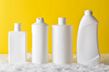 Plastic white bottles stand on a yellow background. Cleaning and disinfection of premises.