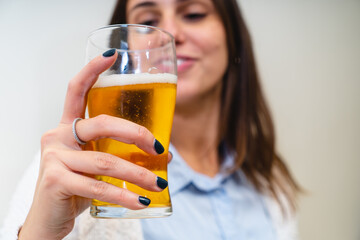 Happy woman holding a glass of beer - people, food and drink lifestyle concept