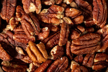 Pecan on dark background. Healthy fat. Heap shelled Pecans nut. Close up. Keto diet. Studio shoot. Top view