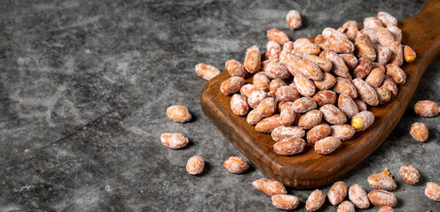 Salted peanuts on dark background. Peanuts on wood serving board. Studio shoot. Empty space for text. Copy space