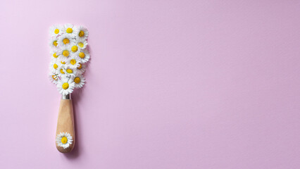 Creative layout of white flowers and paint brush on light pink backround