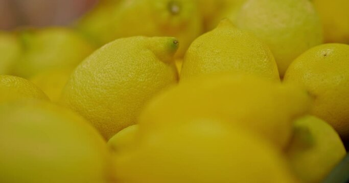 yellow ripe lemons , macro shot in grocery store, fresh food market, close up view, 4K, Prores