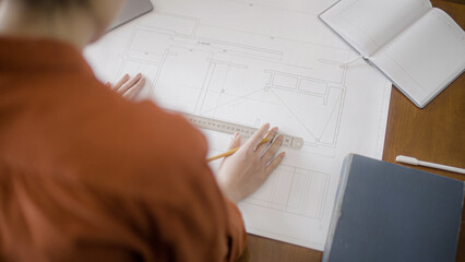 Female student making drawing of building plan, diploma project, closeup
