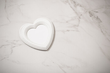 wooden frame in form heart on white marble background