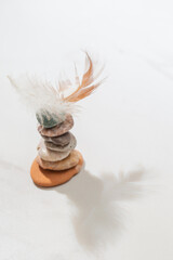 cairn with bird feather on white background