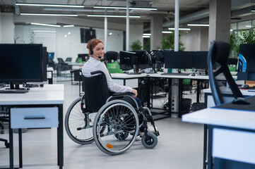 Fototapeta na wymiar Caucasian woman moves around the office in a wheelchair. Female call center worker.