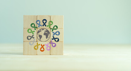 World cancer day (February 4). Colorful ribbons on wooden cube blocks background, cancer awareness,...